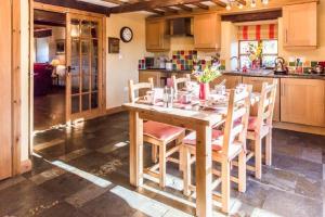 eine Küche mit einem Holztisch und Stühlen in der Unterkunft Siabod Luxury Cottage in Betws-y-coed