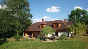 dom z dachem gambrel na trawniku w obiekcie Forest Rustic Apartment Brdy w mieście Buková