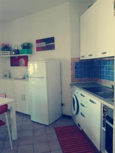 kuchnia z białą lodówką i zmywarką do naczyń w obiekcie Appartamento In Residence w mieście Santa Teresa Gallura