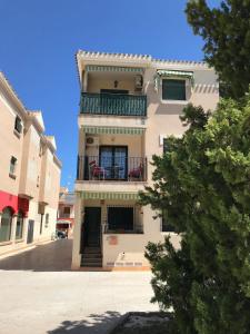 un edificio con un balcón con sillas rojas. en Sheron's Apartment, en Los Alcázares