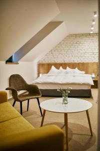 um quarto com uma cama e uma mesa com um vaso de flores em Hotel a Hostinec Slunce em Osečná