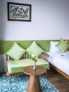 a room with two beds and a table with a couch at Vinh Hung Old Town Hotel in Hoi An