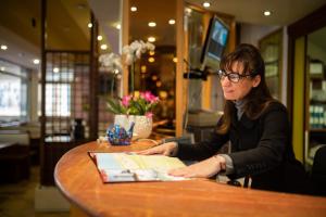Una donna seduta a un tavolo in un ristorante di Hotel Kennedy a Lido di Jesolo