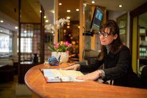 Kobieta siedząca przy stole w restauracji w obiekcie Hotel Kennedy w mieście Lido di Jesolo