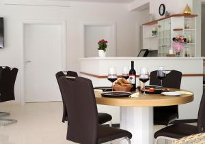 a dining room with a table and wine glasses at Cool Šilo Appartement Resort in Šilo