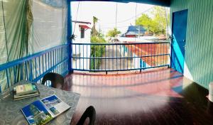 einen Balkon mit einem Tisch und Blick auf ein Boot in der Unterkunft Baba's Guest House By The Sea in Batu Feringgi