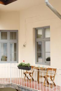 a table and chairs on a balcony with windows at Stylish Flat in the Heart of Historical Center in Timişoara
