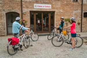 a group of people standing with bikes outside a building at Hotel Casa a Colori Venezia in Dolo