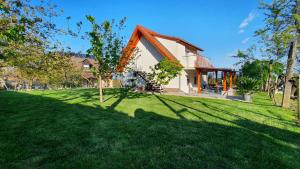 ein Haus mit einem grünen Garten mit Bäumen davor in der Unterkunft Mandula Apartmanok in Badacsonytomaj