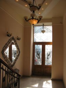 a hallway with a door with a mirror and a chandelier at Apartments Iris69 in Varna City