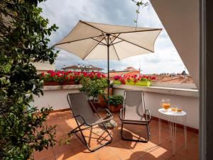 patio z 2 krzesłami i stołem z parasolem w obiekcie Casa di Anna w mieście Pesaro