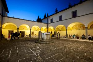 un grupo de personas sentadas en el patio de un edificio en Convento del Carmine 4, en Fivizzano