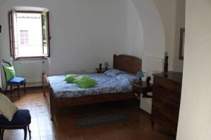 Un dormitorio con una cama con una almohada verde. en Convento del Carmine 4, en Fivizzano