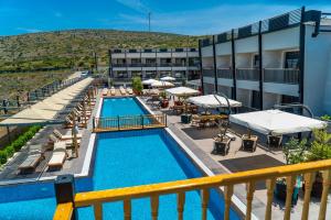 a view of a hotel pool with chairs and umbrellas at Kosa Otel Çeşme in Çeşme