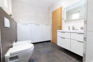a white bathroom with a toilet and a sink at Apartment Svemir in Primošten +24 photos