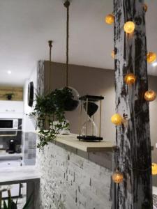 a kitchen with a counter with a clock and lights at Studio zen et cosy, neuf en pleine ville in Saint-Claude