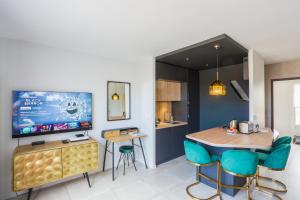 Una cocina y un comedor con una mesa y un televisor. en Lyon Premium - 7e Ciel Rooftop Panoramique, en Lyon