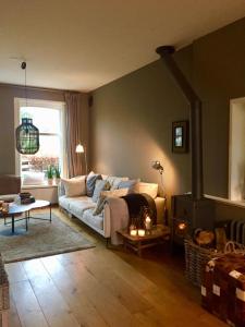 a living room with a couch and a fireplace at Charming countryhouse near Amsterdam in Abcoude