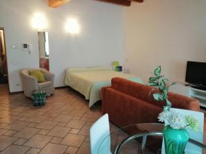 a living room with a bed and a couch and a tv at Soggiorno in Centro Storico in Vimercate