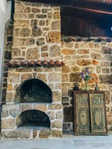 a stone fireplace with a wooden cabinet in front of it at The Ninova in Antalya
