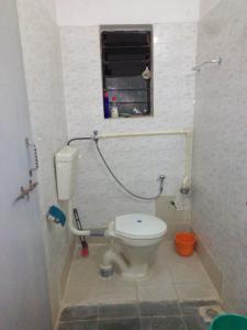 a small bathroom with a toilet and a window at SANJOG Homestay in Nagpur +17 photos