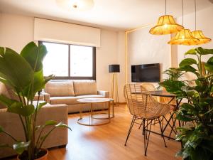 salon z kanapą i stołem w obiekcie Stylish Apartment in the heart of Málaga with Pool w Maladze