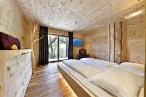 a bedroom with a large bed and a large window at Hotel Ratschingserhof in Racines +96 photos