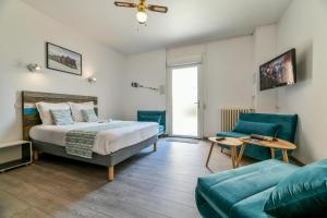 Habitación de hotel con cama y sofá en Logis Hostellerie du Neez, en Gan