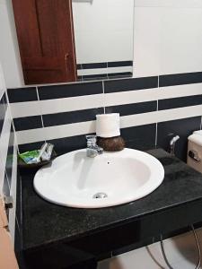 Un baño con un lavabo blanco y un espejo. en TWIN HOME Guesthouse, en Kampot