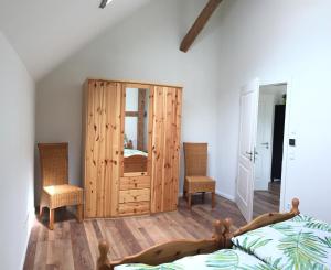 a bedroom with a bed and a wooden cabinet at Ferienwohnung Hof Freimann in Eberhardzell