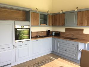 a kitchen with white cabinets and wooden counters at Ferienwohnung Hof Freimann in Eberhardzell