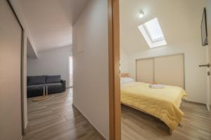 a bedroom with a bed and a couch at Apartman Eva in Vrsi