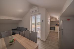 a kitchen and a dining room with a table and a refrigerator at Apartman Eva in Vrsi
