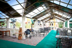 a patio with tables and chairs and a bear on a table at Petrovsky Dvorik in Vozdvizhenskoye