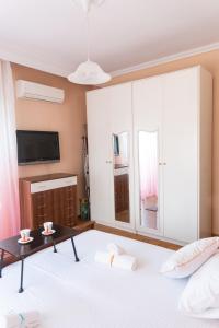 a bedroom with a large bed with a table and a tv at Seashell Apartment in Kavala