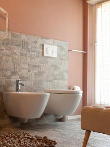 y baño con bañera, aseo y lavamanos. en Spluga Sosta & Hotel, en Dubino