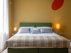1 dormitorio con 1 cama grande y cabecero verde en Spluga Sosta & Hotel, en Dubino