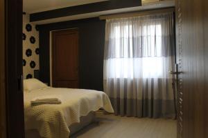 um quarto com uma cama e uma janela em Anastasia em Tbilisi
