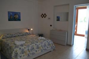1 dormitorio con 1 cama, vestidor y ventana en Casa Vacanze La Vela en Murta Maria