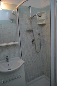 y baño con ducha y lavamanos. en Casa Vacanze La Vela en Murta Maria
