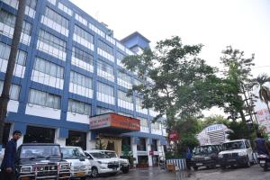 un edificio azul con coches estacionados frente a él en Hotel Rajhans International, en Bhagalpur