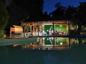 un grupo de personas sentadas en un restaurante junto a una piscina en Zako Apartments, en Limenaria