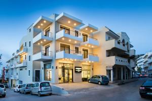 a white building with cars parked in front of it at Aesthetic Apartments in Karpathos Town