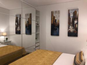 ヴィラモウラにあるApartamento 24 SOLのベッドルーム1室(ベッド2台付)が備わります。壁には絵画が飾られています。