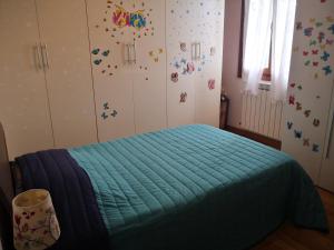 a bedroom with a bed with a blue blanket at Maddy Appartamento in Porto Viro