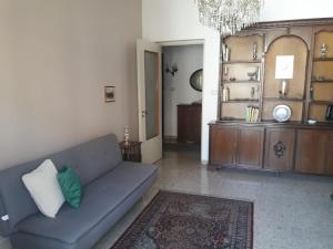 un soggiorno con divano e lampadario pendente di Lidia's home a Catania