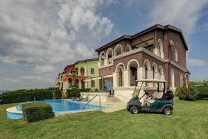 een golfkar geparkeerd voor een huis bij Lighthouse Luxe Estate Apart & Villas in Balchik