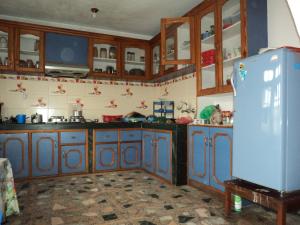 a kitchen with wooden cabinets and a blue refrigerator at Himalayan Vacation Home in Kathmandu