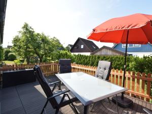 una mesa y sillas con una sombrilla en el patio en Cozy Apartment in Klutz near Sea, en Klütz