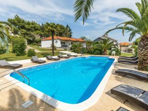 a swimming pool with chaise lounge chairs next to a villa at Modern holiday home with pool in Bibinje